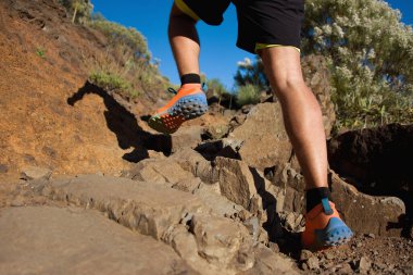 Sporcu ayaklarıyla patikada koşuyor, tabana odaklanıyor. İlan tarzında off road pisti tasarımında antrenman yapıyor.