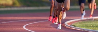 Atletizm ekibi sahada koşuyor. Spor müsabakası için bir yarışta koşuyor ve kazanıyor.
