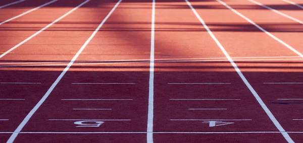 Red running track. Track and field or athletics track finish line with lane numbers