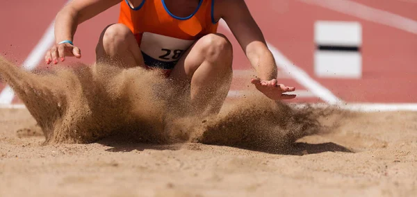 Kvinnlig Idrottsman Längdhopp Landning Sand Spray Landning Längdhopp Spår Och — Stockfoto