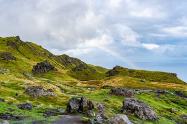 The Sound of Raasay, Skye Adası, İskoçya üzerinde alçak bulutlar ve gökkuşağıyla Storr 'un Yaşlı Adamı' ndan görüntü