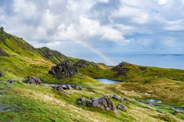 The Sound of Raasay, Skye Adası, İskoçya üzerinde alçak bulutlar ve gökkuşağıyla Storr 'un Yaşlı Adamı' ndan görüntü