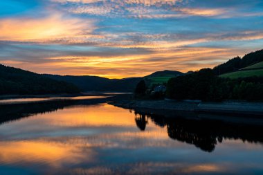 Yukarı Derwent Vadisi 'ndeki Ladybower Rezervuarı' nda Derbyshire, İngiltere 'de dramatik renkli bir gün batımı yaşanıyor.