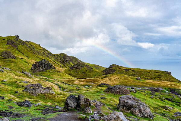 View from The Old Man of Storr with low clouds and rainbow over The Sound of Raasay, Isle of Skye, Scotland
