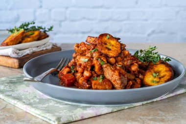 Biftek ve kızarmış muzlu fasulye güveci.