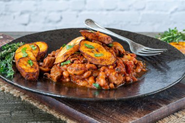 Biftek ve kızarmış muzlu fasulye güveci.