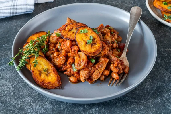 Biftek ve kızarmış muzlu fasulye güveci.