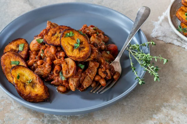 Biftek ve kızarmış muzlu fasulye güveci.