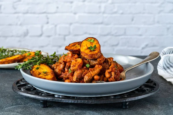 Biftek ve kızarmış muzlu fasulye güveci.