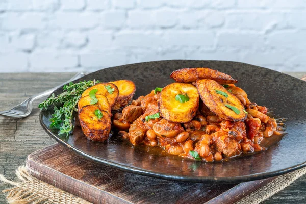 Biftek ve kızarmış muzlu fasulye güveci.