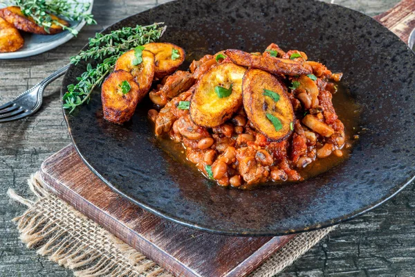 Biftek ve kızarmış muzlu fasulye güveci.