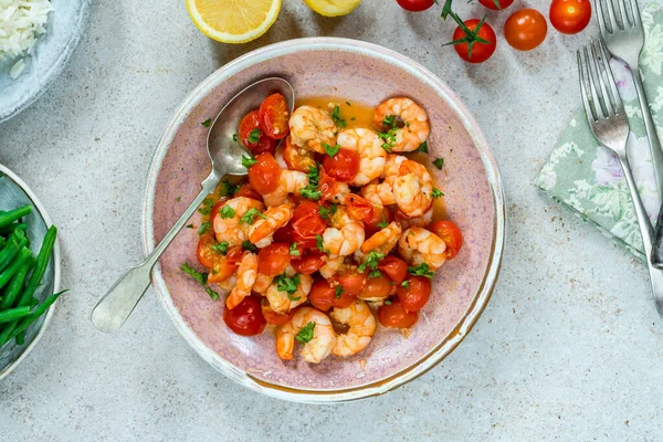 Jumbo king prawn with tomatoes and garlic garnished with fresh parsley- overhead view