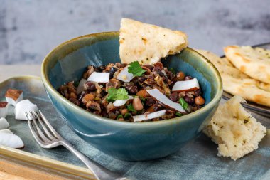 Düz ekmekli vejetaryen fasülye körisi.