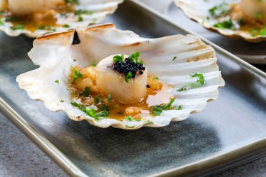 Deniz taraklı kanepeler, kabuklu havyar, limon ve tereyağı sosu.