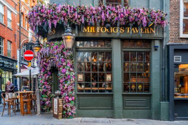 Londra, İngiltere - 11 Kasım 2021: Bay Fogg 'un Tavernası, kaşif Phileus Fogg' un etrafında kurulmuş eski tarz bir taverna ve Londra 'daki Mayfair' de İngiliz barı kapma servisi Noel için dekore edildi..
