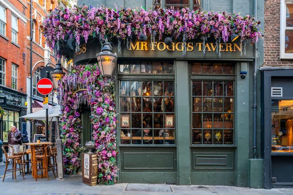 Londra, İngiltere - 11 Kasım 2021: Bay Fogg 'un Tavernası, kaşif Phileus Fogg' un etrafında kurulmuş eski tarz bir taverna ve Londra 'daki Mayfair' de İngiliz barı kapma servisi Noel için dekore edildi..