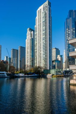 LONDON, UK - 25 Kasım 2021: Canary Wharf 'ın modern gökdelenleri, Londra' daki Millwall Inner Rıhtımı boyunca görülen finans merkezi