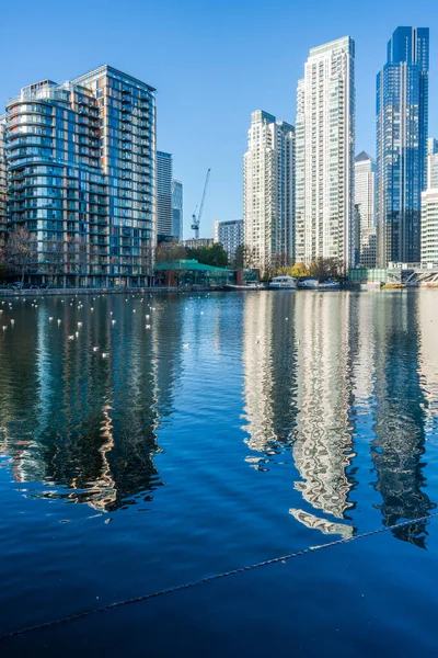LONDON, UK - 25 Kasım 2021: Canary Wharf 'ın modern gökdelenleri, Londra' daki Millwall Inner Rıhtımı boyunca görülen finans merkezi