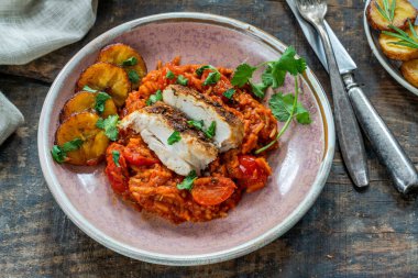 Jollof pilav - kızarmış tavuk göğsü ve kızarmış muz ile baharatlı Afrika pirinç yemeği