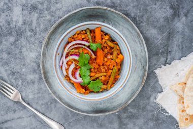 Vejetaryen yeşil körili mercimek ve yeşil ekmek.