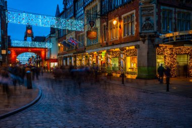 CHESTER, CheSHIRE, İngiltere - 05 Aralık 2021: Eastgate saat kulesi ve Chester 'ın ünlü eski kasabası, şafak vakti Saflar' ı süsleyen Noel ışıkları manzarası.