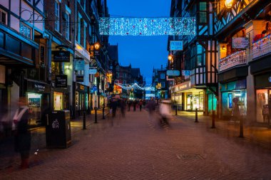CHESTER, CheSHIRE, İngiltere - 05 Aralık 2021: Chester 'ın ünlü eski kasabası, akşam karanlığında Saflar' ı süsleyen Noel ışıklarının asıldığı sıralar.