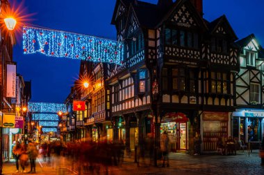 CHESTER, CheSHIRE, İngiltere - 05 Aralık 2021: Chester 'ın ünlü eski kasabası, akşam karanlığında Saflar' ı süsleyen Noel ışıklarının asıldığı sıralar.