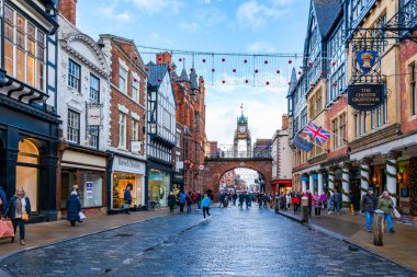 CHESTER, CheSHIRE, İngiltere - 06 Aralık 2021: Eastgate saat kulesi ve Chester 'ın eski kasabasını ünlü Rows mağazalarıyla donatan Noel ışıkları manzarası