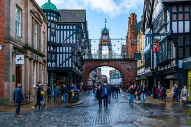 CHESTER, CheSHIRE, İngiltere - 06 Aralık 2021: Eastgate saat kulesi ve Chester 'ın eski kasabasını ünlü Rows mağazalarıyla donatan Noel ışıkları manzarası