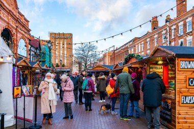 CHESTER, CheSHIRE, İngiltere - 06 Aralık 2021: İnsanlar festival sezonunda kasaba meydanının dışındaki ve Chester Katedrali yakınlarındaki Noel pazarına gitmenin keyfini çıkarıyorlar