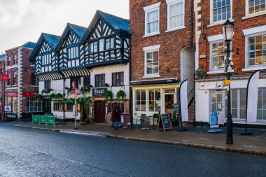 CHESTER, CheSHIRE, İngiltere - 06 Aralık 2021: Geleneksel siyah-beyaz kereste çerçeveli Tudor tarzı binalarla tarihi şehir Chester 'ın sokak manzarası