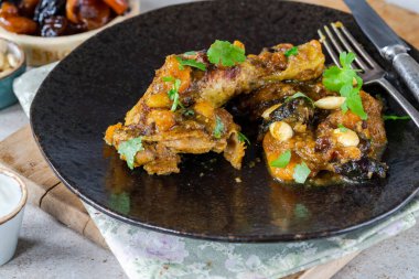 Karamelli erik, kayısı ve kızarmış bademle birlikte tavuk budu etiketi.