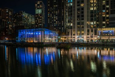 LONDON, İngiltere - 09 Ocak 2022: Londra 'nın finans merkezi olan Canary Wharf' taki Millwall İç Rıhtımı boyunca modern gökdelenlerin gece görüşü.