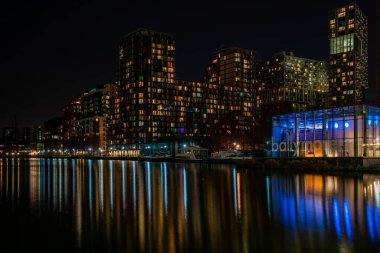 LONDON, İngiltere - 09 Ocak 2022: Londra 'nın finans merkezi olan Canary Wharf' taki Millwall İç Rıhtımı boyunca modern gökdelenlerin gece görüşü.