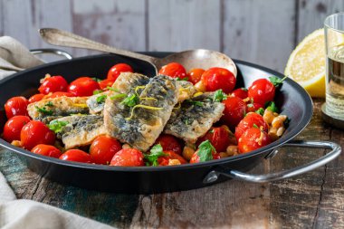 Nohut, vişneli domates, limon ve maydanozlu sardalya.