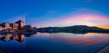 TRONDHEIM, NORway - 08 Mart 2022: Trondheim limanının akşam manzarası. Kasabanın merkezine 5 dakikalık yürüme mesafesinde ana dükkanlar, barlar ve restoranlar iskeleye yakın.