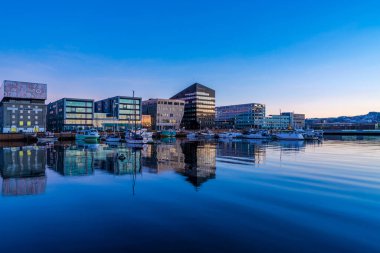 TRONDHEIM, NORway - 08 Mart 2022: Trondheim limanının akşam manzarası. Kasabanın merkezine 5 dakikalık yürüme mesafesinde ana dükkanlar, barlar ve restoranlar iskeleye yakın.