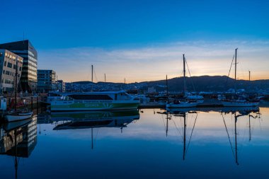 TRONDHEIM, NORway - 08 Mart 2022: Trondheim limanının akşam manzarası. Kasabanın merkezine 5 dakikalık yürüme mesafesinde ana dükkanlar, barlar ve restoranlar iskeleye yakın.