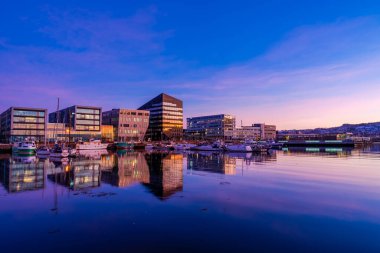 TRONDHEIM, NORway - 08 Mart 2022: Trondheim limanının akşam manzarası. Kasabanın merkezine 5 dakikalık yürüme mesafesinde ana dükkanlar, barlar ve restoranlar iskeleye yakın.
