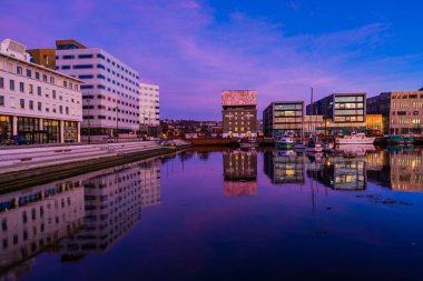 TRONDHEIM, NORway - 08 Mart 2022: Trondheim limanının akşam manzarası. Kasabanın merkezine 5 dakikalık yürüme mesafesinde ana dükkanlar, barlar ve restoranlar iskeleye yakın.