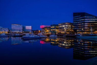 TRONDHEIM, NORway - 08 Mart 2022: Trondheim limanının akşam manzarası. Kasabanın merkezine 5 dakikalık yürüme mesafesinde ana dükkanlar, barlar ve restoranlar iskeleye yakın.