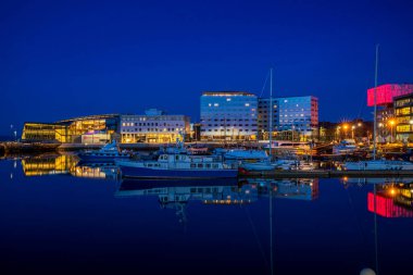 TRONDHEIM, NORway - 08 Mart 2022: Trondheim limanının akşam manzarası. Kasabanın merkezine 5 dakikalık yürüme mesafesinde ana dükkanlar, barlar ve restoranlar iskeleye yakın.