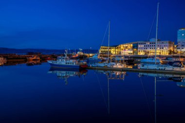 TRONDHEIM, NORway - 08 Mart 2022: Trondheim limanının akşam manzarası. Kasabanın merkezine 5 dakikalık yürüme mesafesinde ana dükkanlar, barlar ve restoranlar iskeleye yakın.