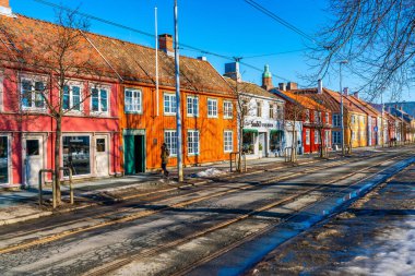 TRONDHEIM, NORway - 11 Mart 2022: Trondheim 'daki renkli ahşap evlerin sokak manzarası. Şehir Trondheim Fjord 'un güney kıyısında yer almaktadır ve Norveç' in en kalabalık üçüncü şehridir.