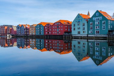 Norveç, Trondheim 'ın Brygge semtindeki Nidelva nehrinde yansıyan renkli ahşap evler.