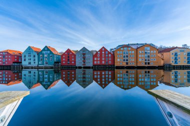 Norveç, Trondheim 'ın Brygge semtindeki Nidelva nehrinde yansıyan renkli ahşap evler.