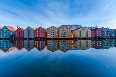 Norveç, Trondheim 'ın Brygge semtindeki Nidelva nehrinde yansıyan renkli ahşap evler.