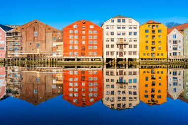 Norveç, Trondheim 'ın Brygge semtindeki Nidelva nehrinde yansıyan renkli ahşap evler.