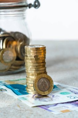 Para - arka planda 1 sterlin ve bir kavanoz bozuk para - tasarruf ve harcama kavramı