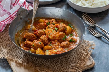 Sosisli köfte ve köri soslu patates ve pilav.